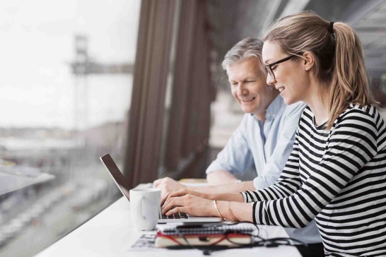 Junge Frau und Mann rufen Electronic Banking der Oberbank am Laptop auf.