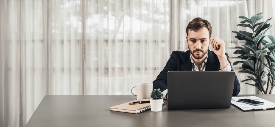 Mann sitzt vor Laptop