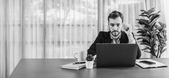 Mann sitzt vor Laptop