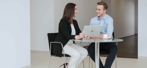 Frau und Mann schauen in einen Laptop